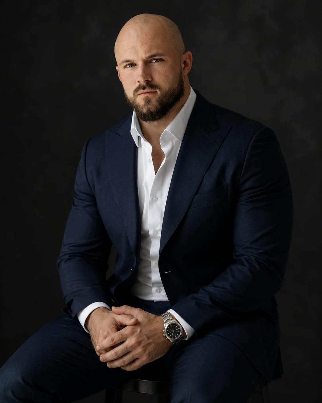 Chancellor Aven, COO and operational leader, in a navy suit against a dark studio backdrop